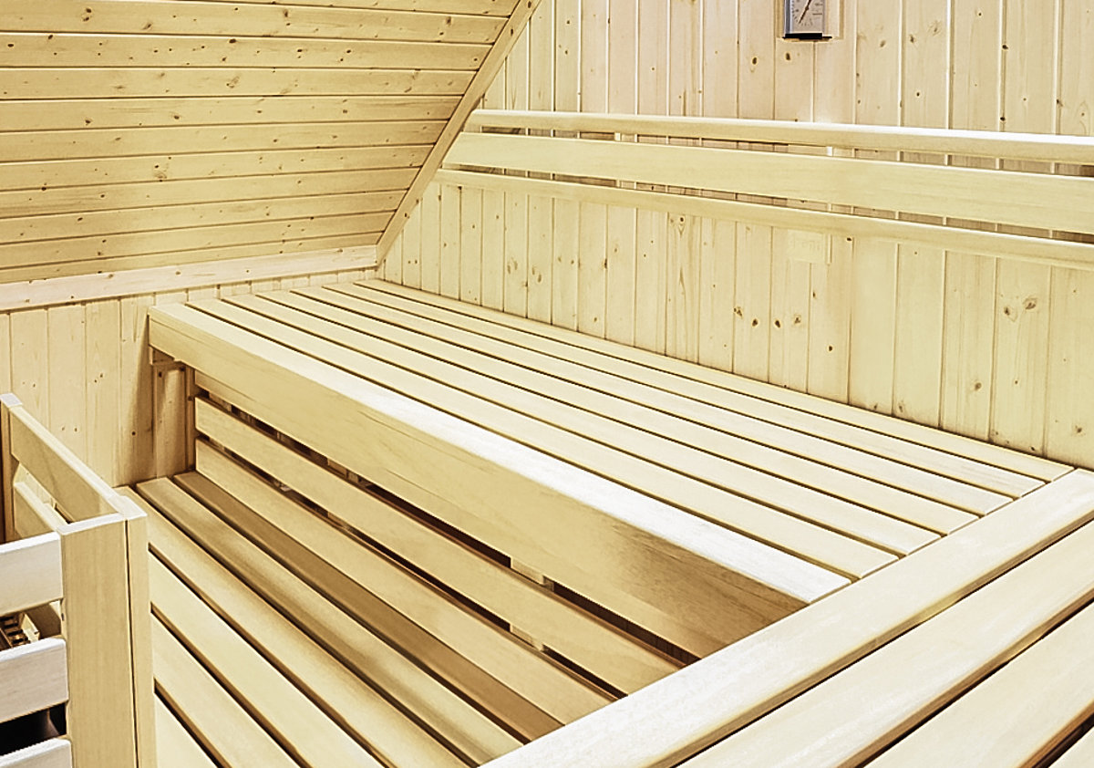 Interieur van een op maat gemaakte sauna onder een schuin dak.
