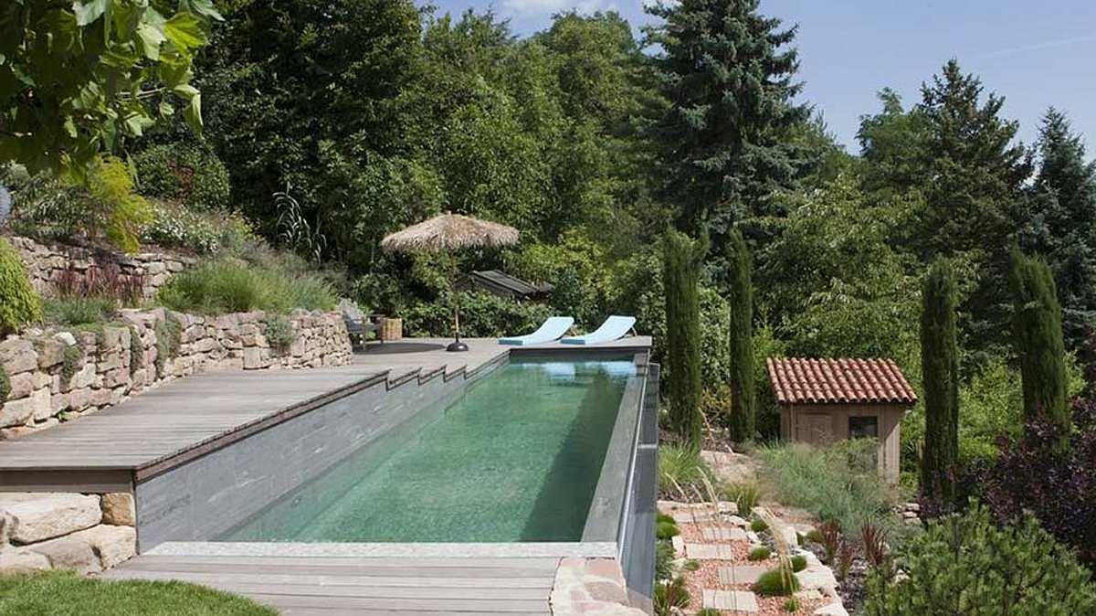 Een betonnen zwembad zonder binnenbekleding op een steile helling.