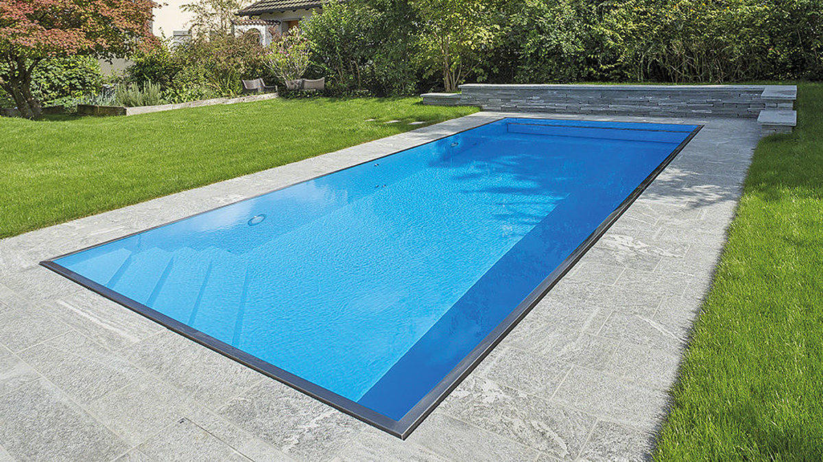 Een polystone-zwembad met overloopgoot in de tuin.