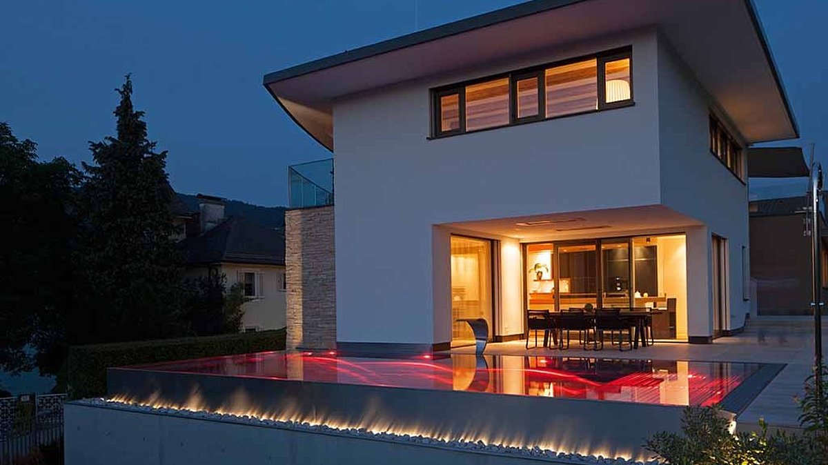 Een verlicht RVS-zwembad voor een huis.