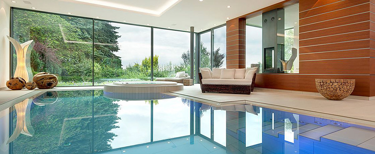 Een wellnessruimte met sofa, zwembad en verhoogd platform whirlpool.