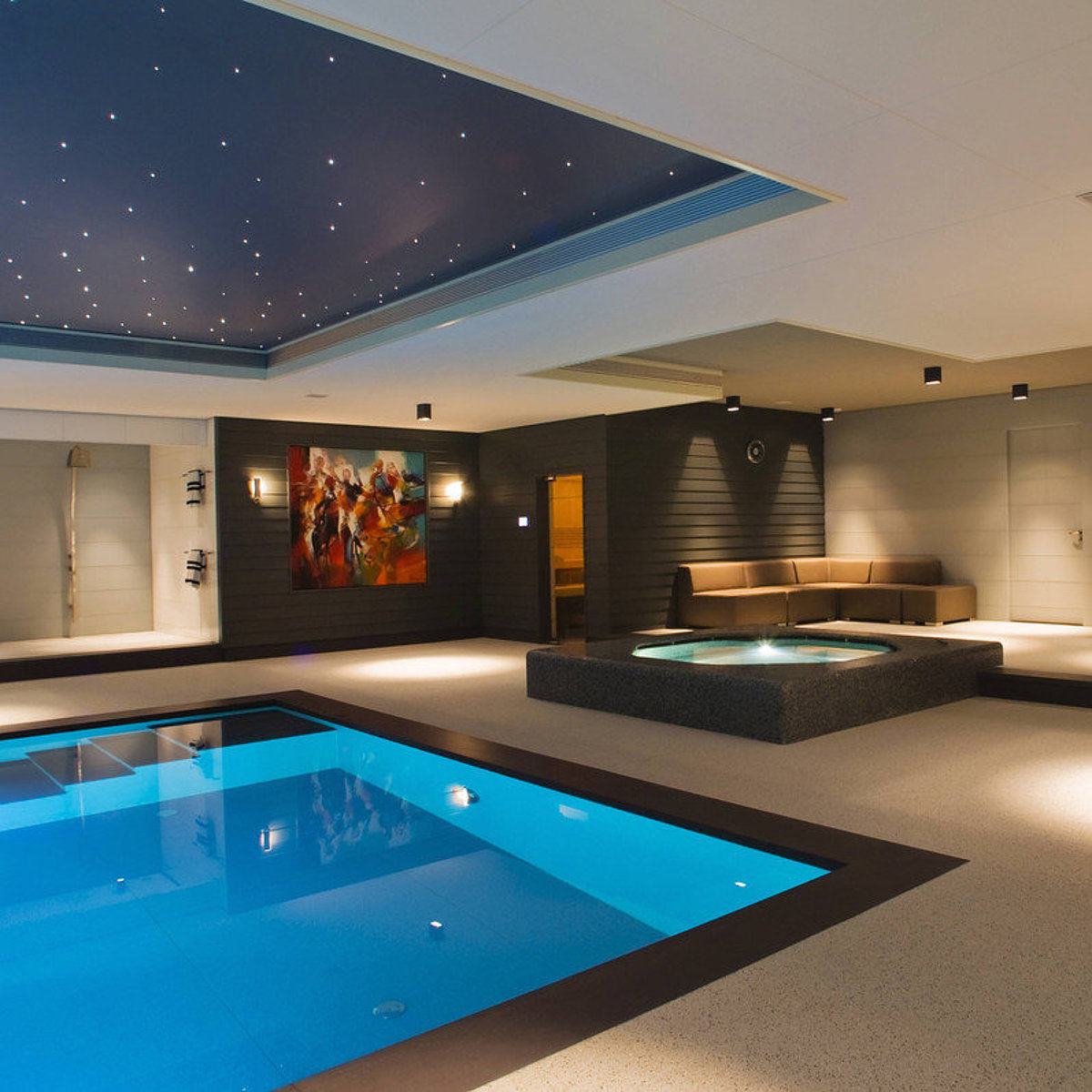 Ein Wellnessbereich mit Pool, Whirlpool, Duschbereich und Beleuchtung – inklusive Sternenhimmel an der Decke.