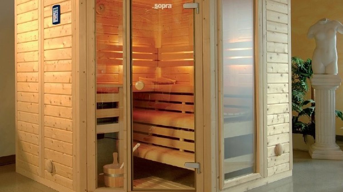 Een massief houten sauna met hoekinstap.