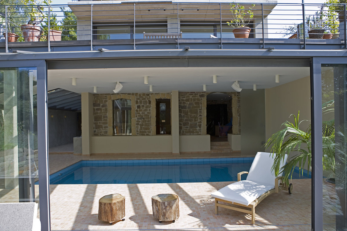 Ein Indoorpool mit einer pinken Deckenbeleuchtung.
