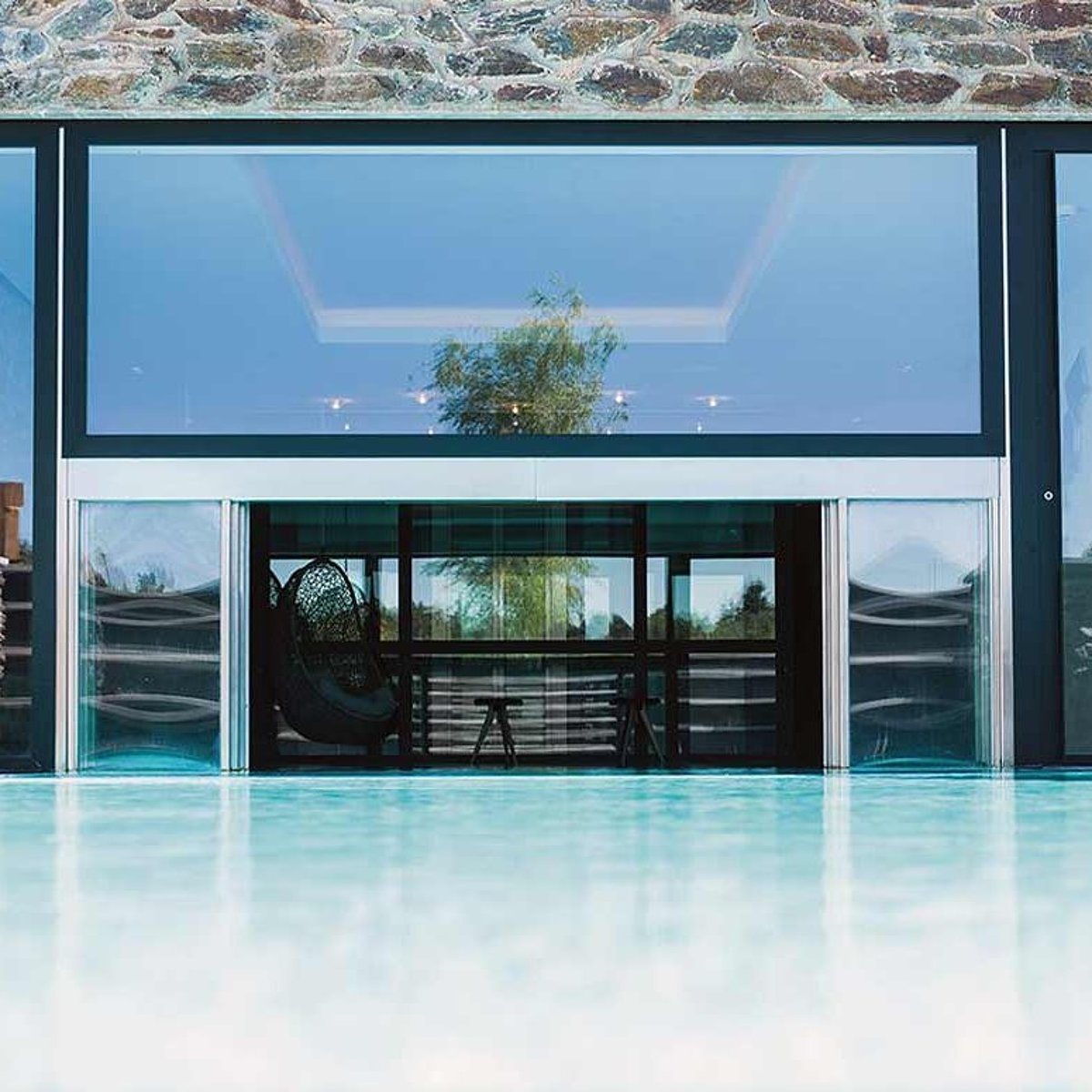 Ein Indoor-Outdoor-Pool mit geöffneten Glasschiebetüren.