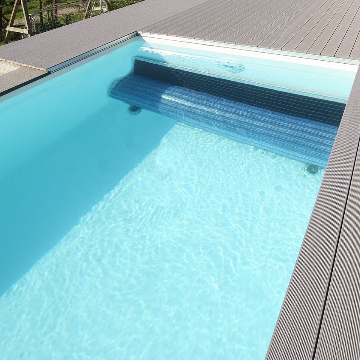 Een betonnen zwembad met foliebekleding.