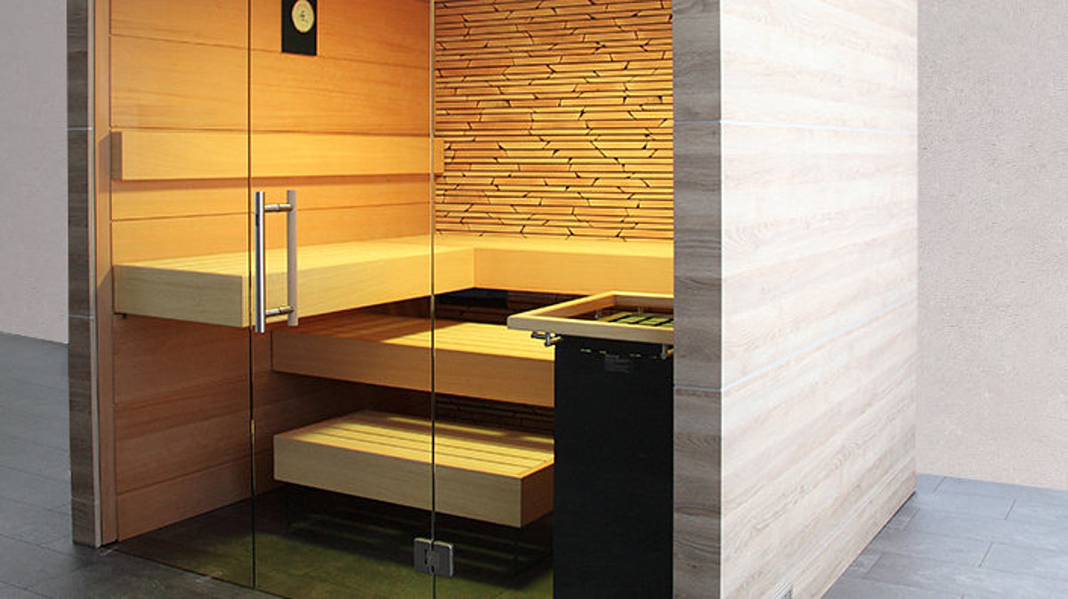 Eine beleuchtete Indoor-Sauna mit Dekorplatten und Glaswand.
