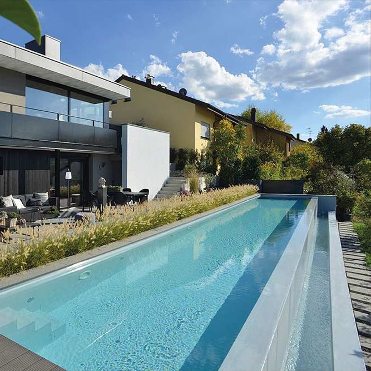 Een smal lang zwembad op een terras.