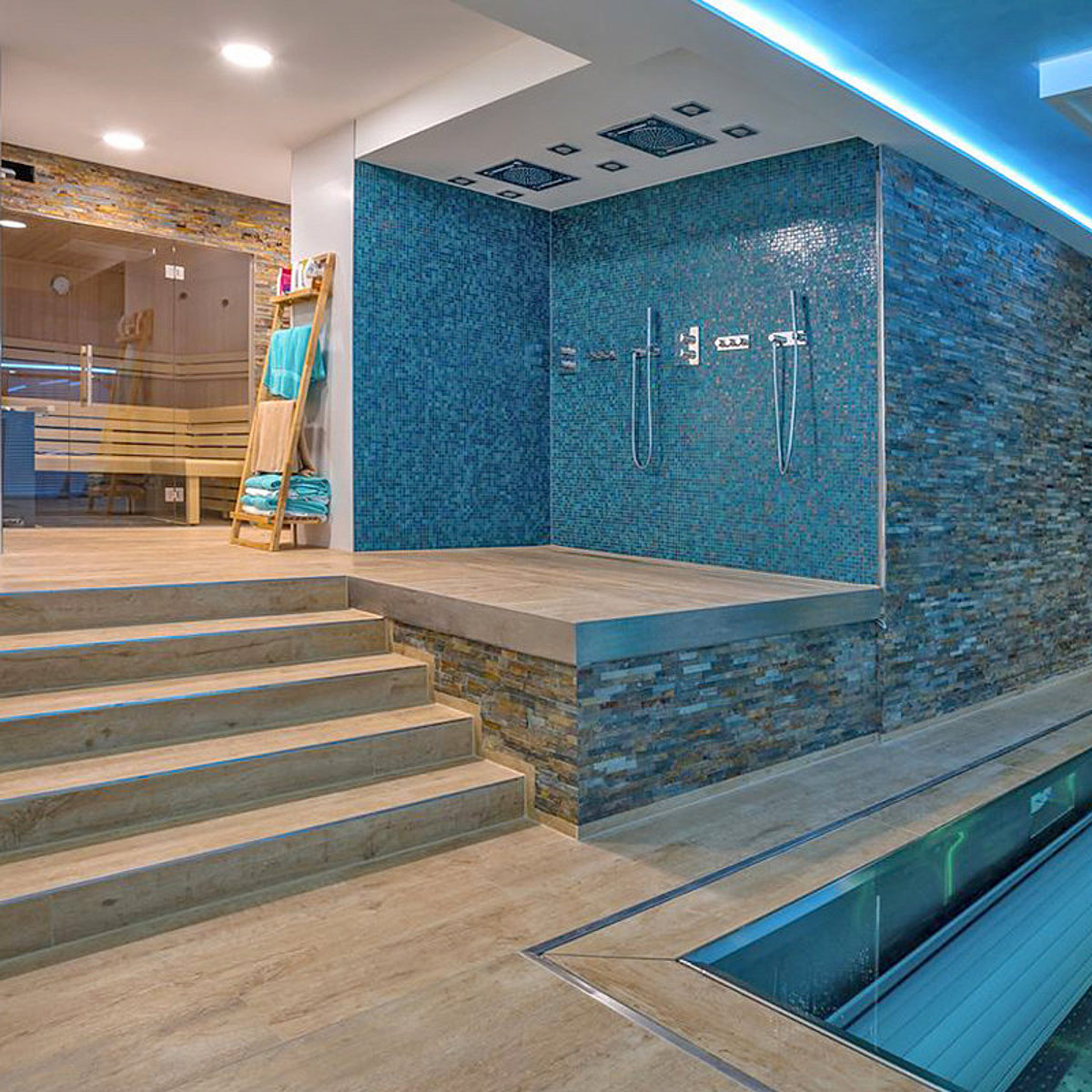 Ein Pool. Daneben eine Treppenanlage, die zum Duschbereich und der Sauna führt.