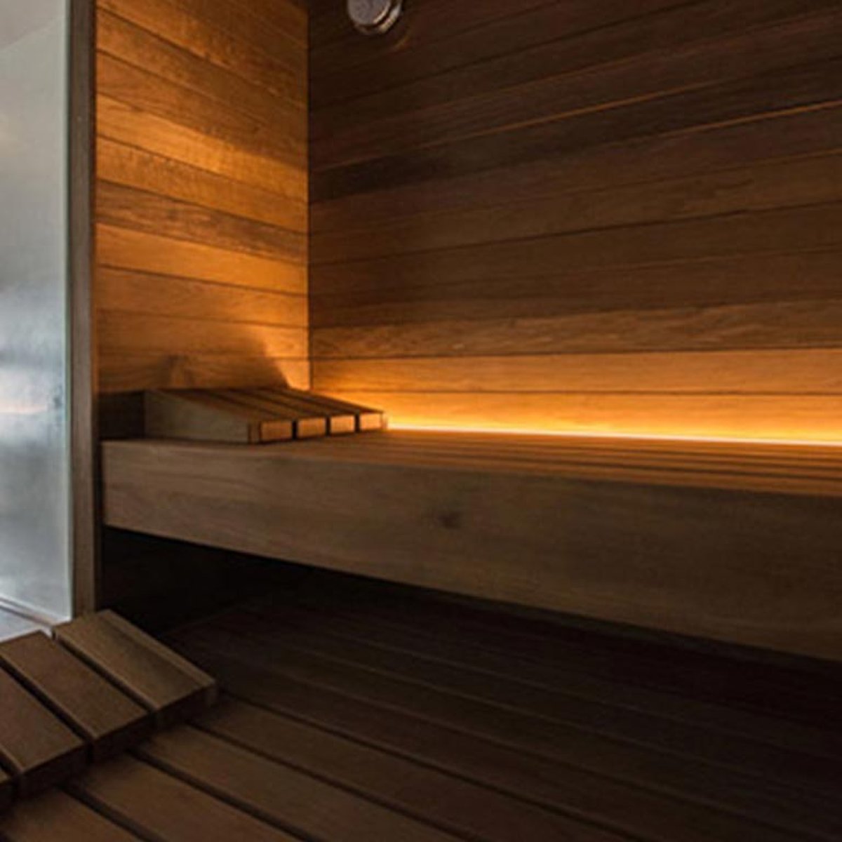 Het discreet verlichte interieur van een sauna.