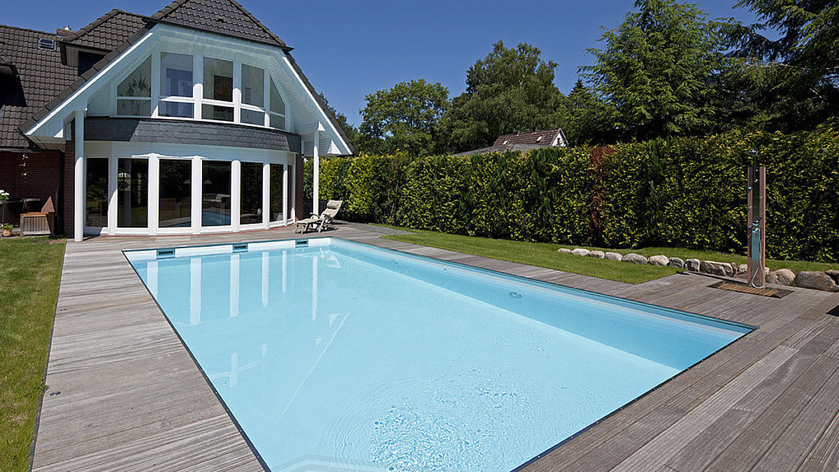 Ein Skimmerpool vor einem Wohnhaus. 
