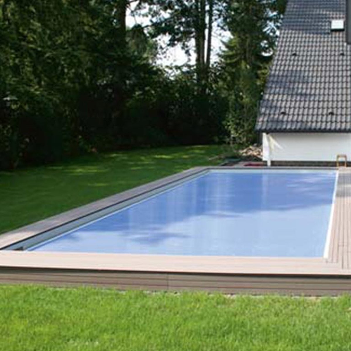 Zwembad omgeven door een houten dek in de tuin.