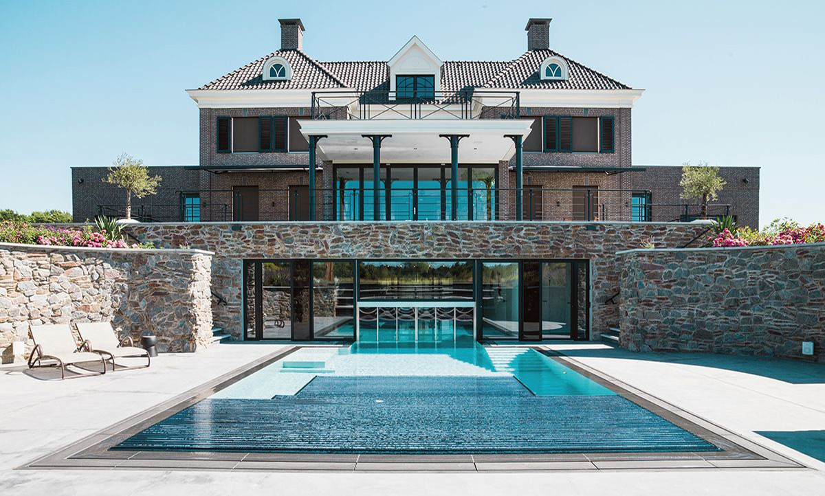 Ein Indoor-Outdoor-Pool mit Schleuse und dem zugehörigen Wohngebäude.