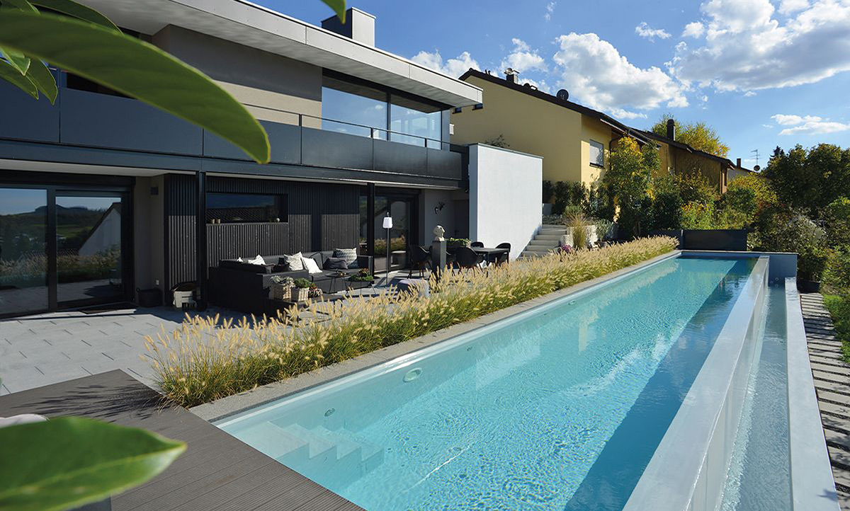 Ein schmaler langer Pool auf einer Terrasse.