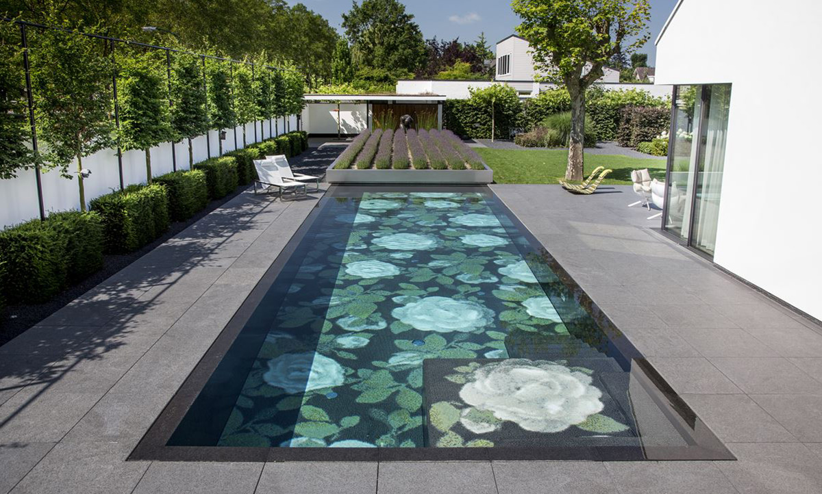 Ein aufwändig gestalteter Terrassen-Pool mit Blumenmosaik und fahrbarem begrünten Deck zur Abdeckung.