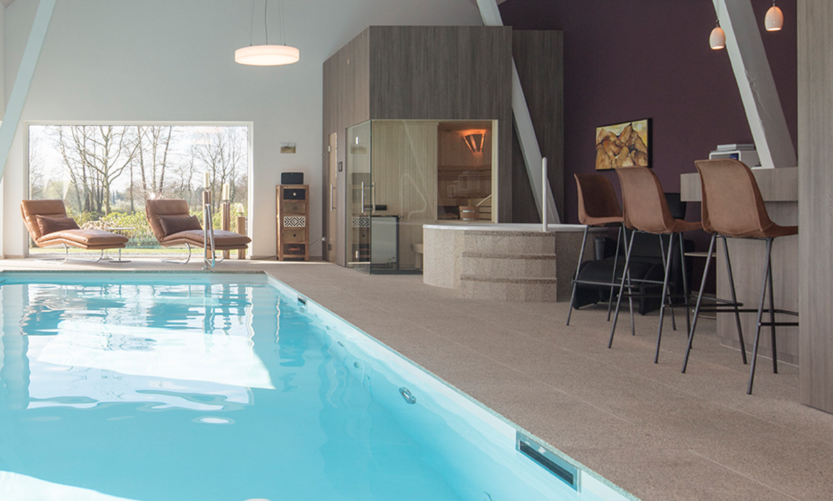 Schlicht gestaltete Schwimmhalle mit Indoor-Pool, Sauna und Whirlpool.