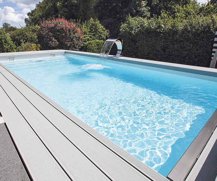 Een polystone-zwembad met watervaldouche geïntegreerd in een terras.