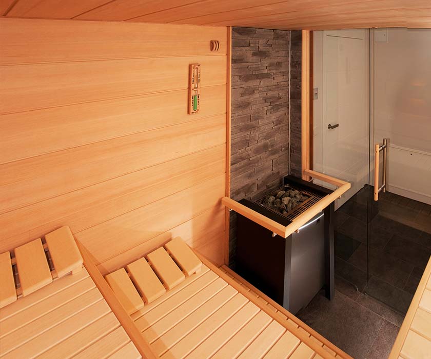 Het interieur van een moderne sauna met glazen deur.