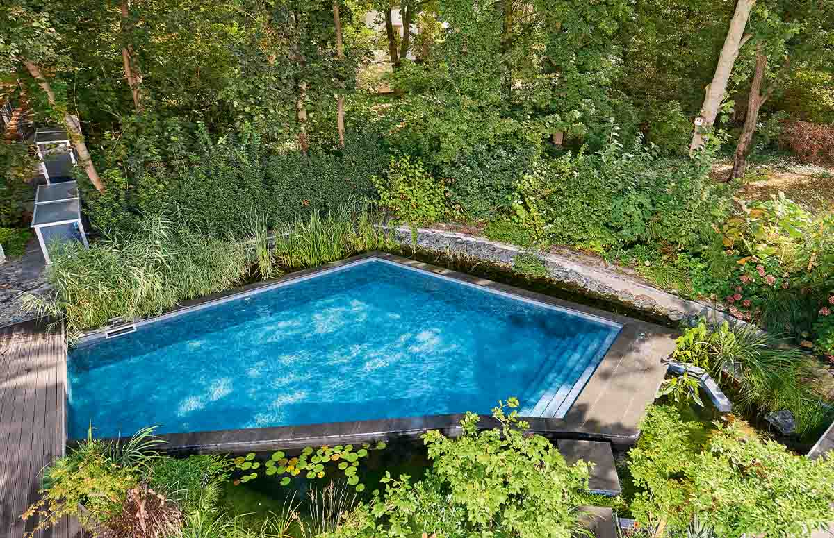 Ein Schwimmbecken in freier Form im Garten.